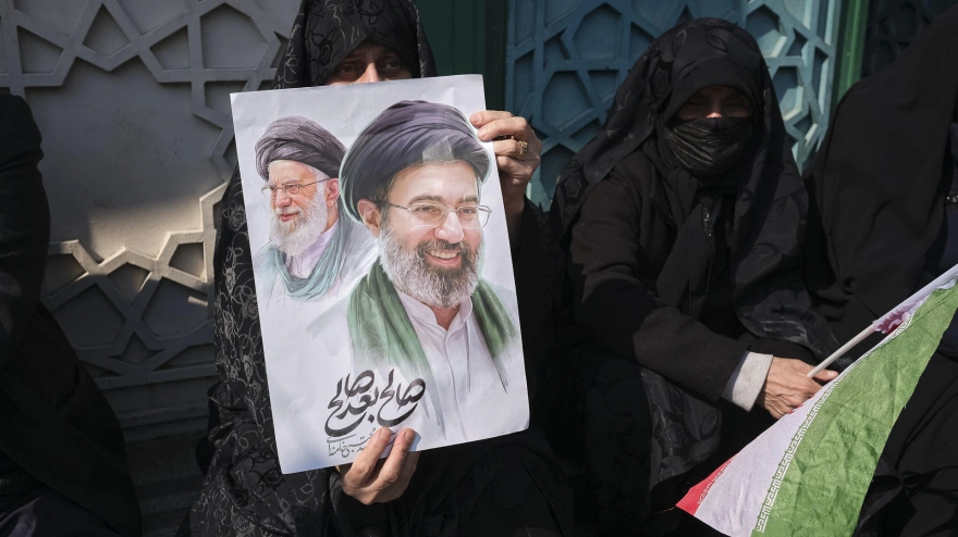 Un mujer porta una pancarta del líder supremo de Irán, Mojtaba Jamenei