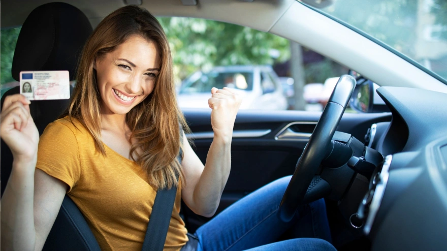Una chica feliz con el carnet de conducir  recién sacado