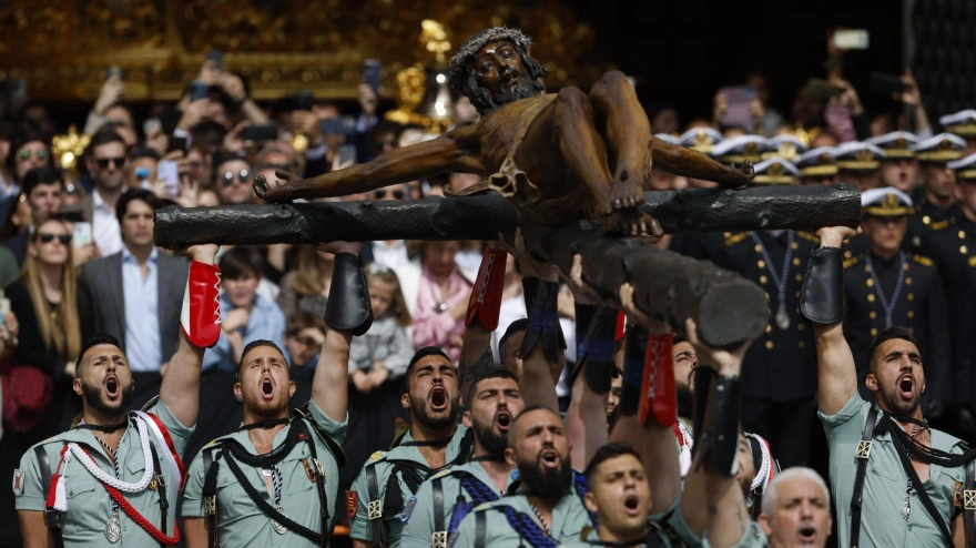 Miembros de la Legión portan el Cristo de la Buena Muerte, de la Cofradía de Mena, por las calles de Málaga este Jueves Santo en uno de los eventos más populares de la Semana Santa andaluza
