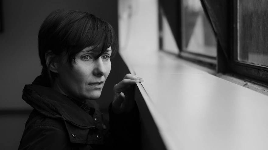 Una mujer mira por la ventana