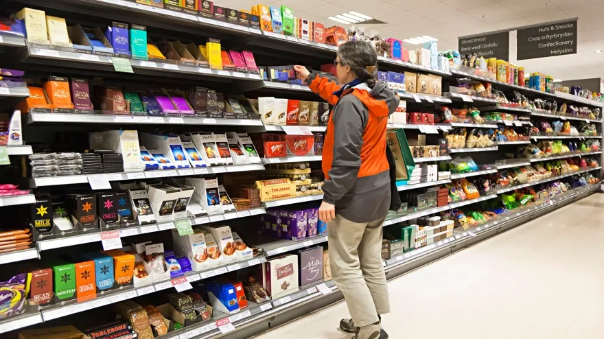 Una mujer comprando chocolate en un supermercado