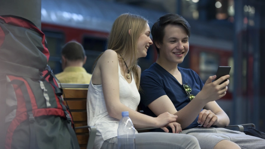 Una pareja joven se conecta a una red wifi pública mientras navega por Internet