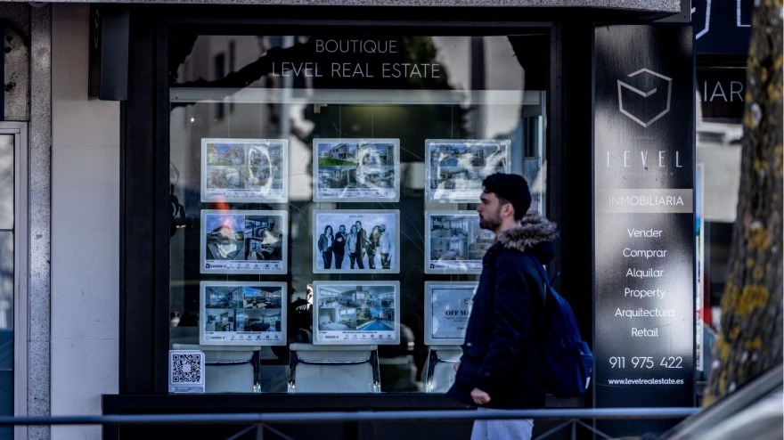 Un joven pasa frente a una inmobiliaria