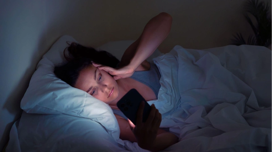 Una mujer se despierta y mira el móvil
