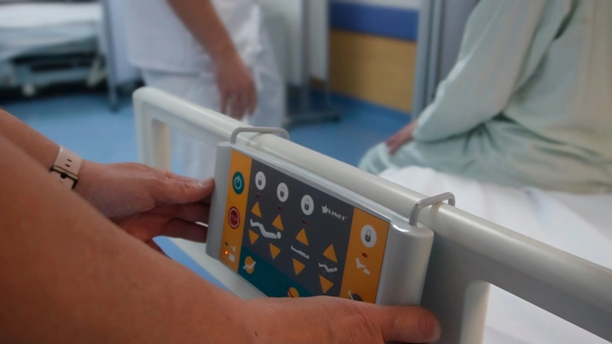 Celadores del Hospital Virgen Macarena realizando maniobras en una camilla