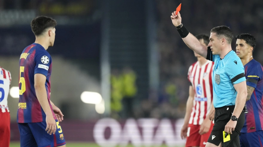 El colegiado István Kovács (d) muestra cartulina roja al defensa del FC Barcelona Pau Cubarsí (i) durante el encuentro correspondiente a la ida de los cuartos de final de la Liga de Campeones que disputan este miércoles FC Barcelona y Atlético de Madrid en el estadio Camp Nou, en Barcelona