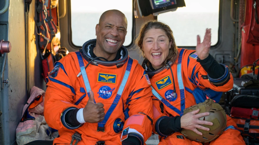 Fotografía cedida con la NASA donde aparece el piloto de la misión Artemis II, el astronauta Victor Glover (i), y la especialista de misión, la astronauta Christina Koch (d), saludando desde un helicóptero MH-60 Seahawk de la Armada estadounidense tras salir de la nave espacial Orion este viernes, en el océano Pacífico, frente a la costa de California (Estados Unidos)
