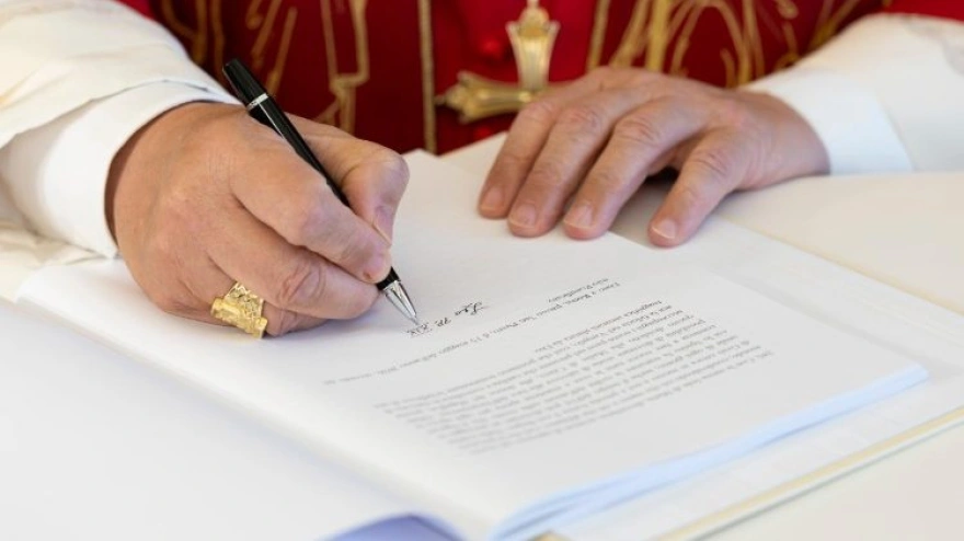 León XIV firmando su primera encíclica, 'Magnifica Humanitas'