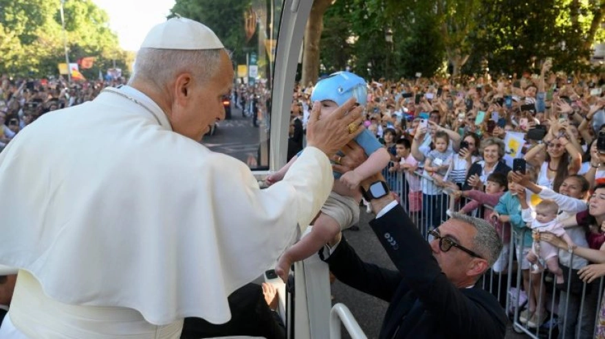 El Papa con uno de los bebés a los que bendice a lo largo del recorrido del papamóvil