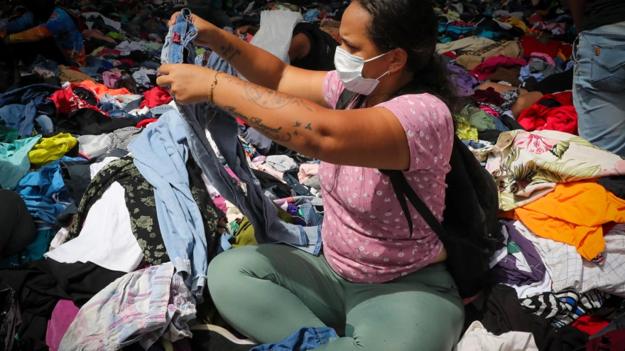 Una persona selecciona ropa en La Guaira (Venezuela).