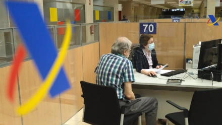 Una empleada atiende a una persona de manera presencial desde una oficina de la Agencia Tributaria