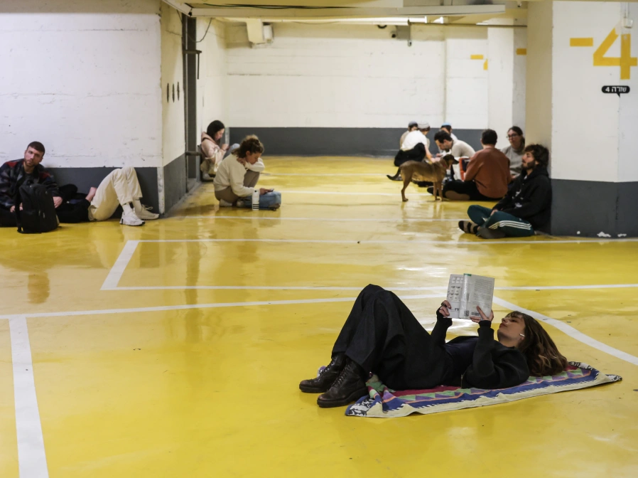 28 February 2026, Israel, Tel Aviv: People they take shelter in an underground parking lot following alarms for incoming missiles from Iran. Iran has launched missiles towards Israel following joint US-Israeli strikes on the country, the Israeli Defence Forces (IDF) said on Saturday. Photo: Oren Ziv/dpa28/2/2026 ONLY FOR USE IN SPAIN