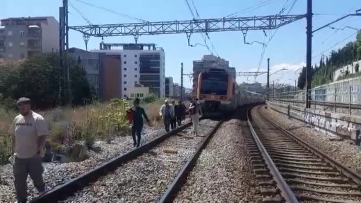 Pasajeros de un tren de rodalias caminando por la vía
