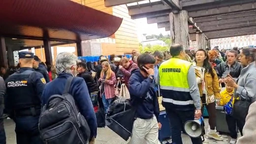 El personal de Renfe informa a los viajeros que están en la calle con megáfono en mano