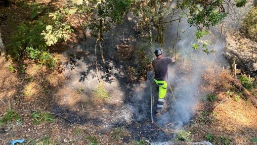 Antonio, brigadista, intenta evitar que se reavive un incendio en Carballeda de Avia